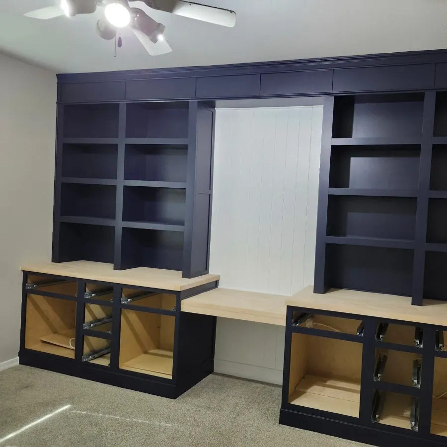 A built-in desk and shelving unit painted navy blue