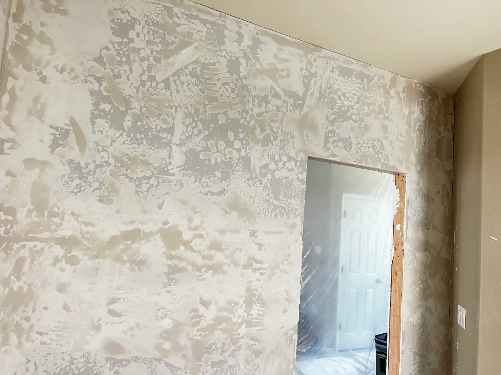 New drywall mudded and skimmed around a doorway, ready for texture and paint