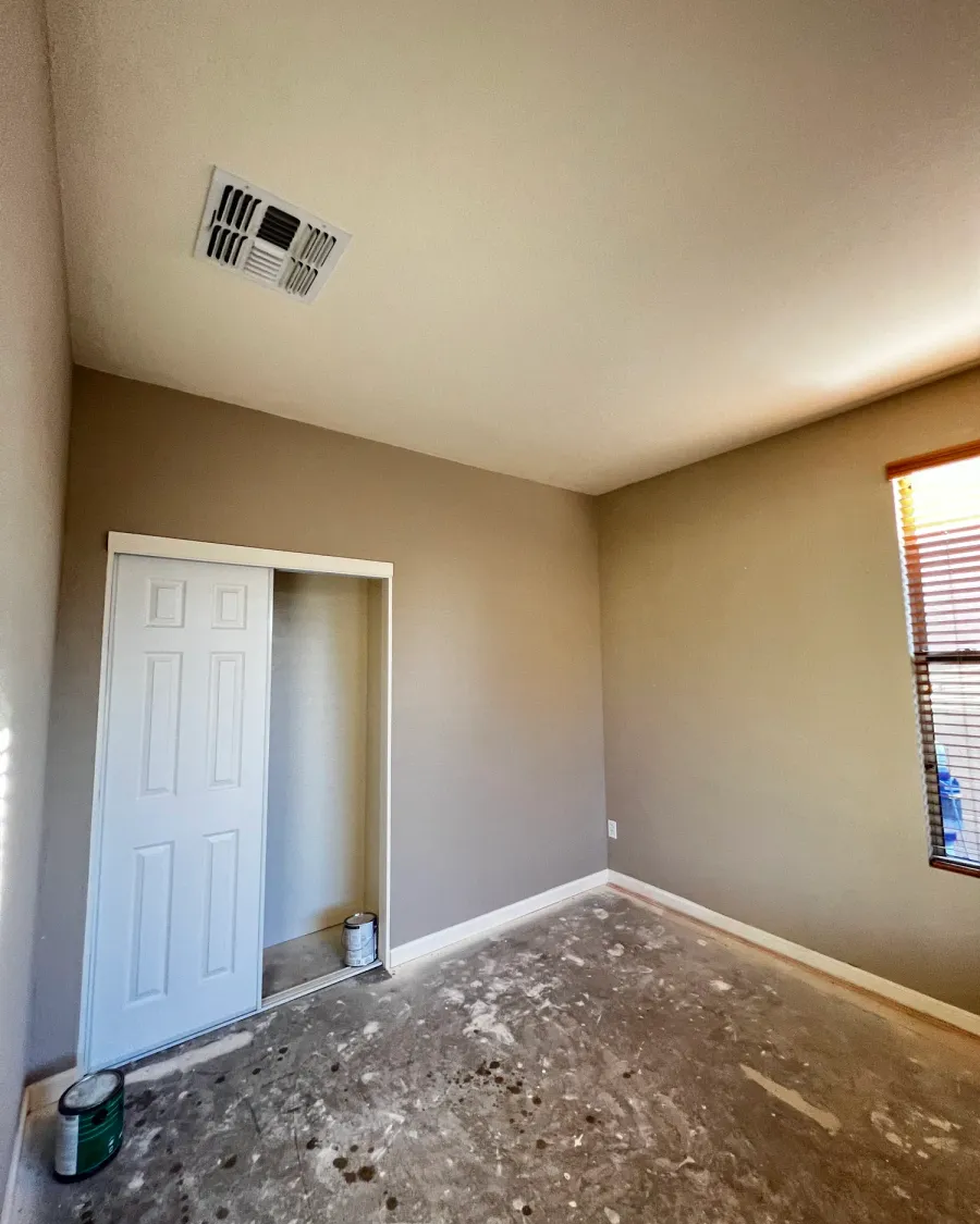 A finished room with smooth, freshly painted walls and a white closet door