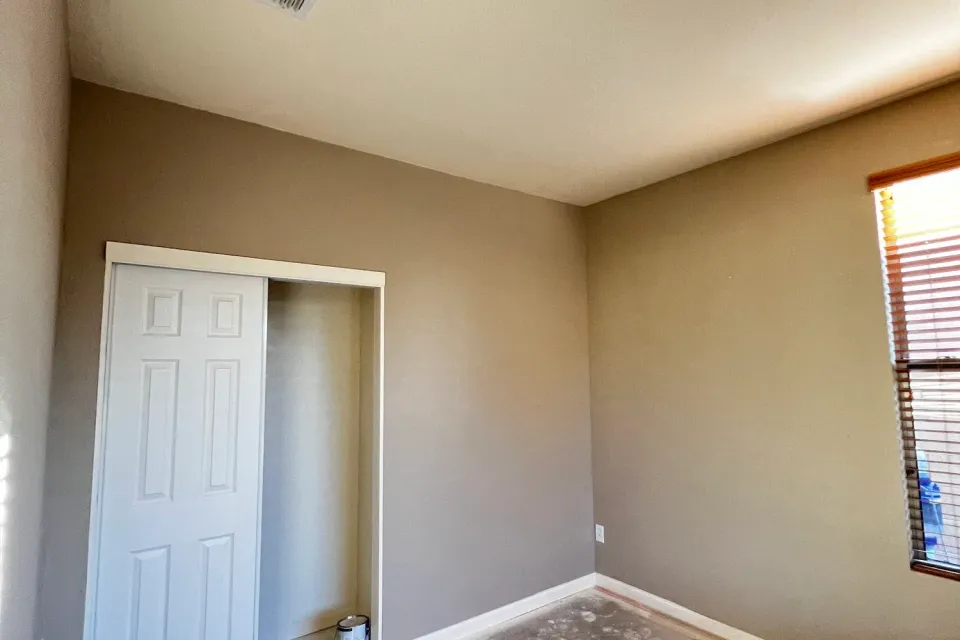 A finished room with smooth, freshly painted walls and a white closet door