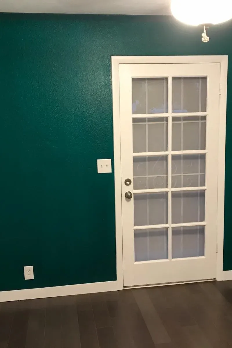 The same wall painted deep green around the white French door