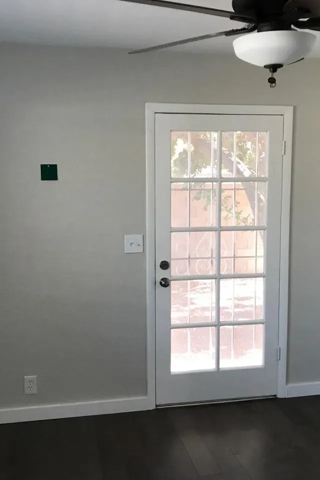 A light grey room with a glass-paned door, before the accent wall