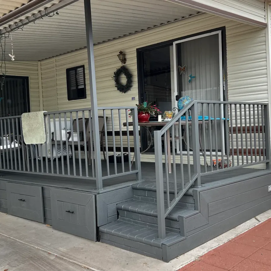 A porch deck with steps and railings painted grey