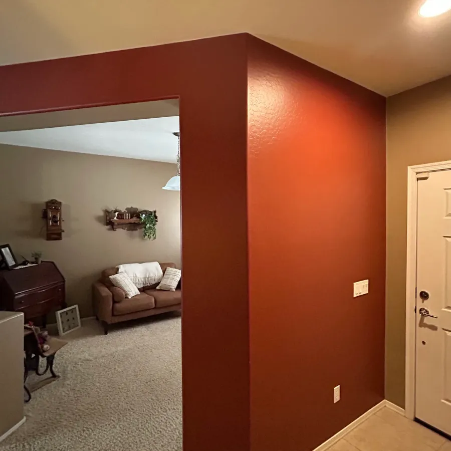 A deep red accent wall at the end of a hallway