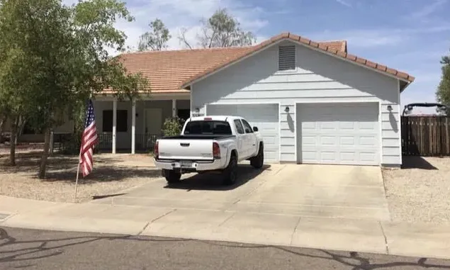 A single-story Gilbert home in white siding with a tile roof, before the work