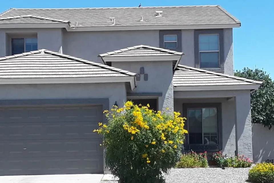 A two-story grey stucco home with a tile roof in Gilbert, Arizona