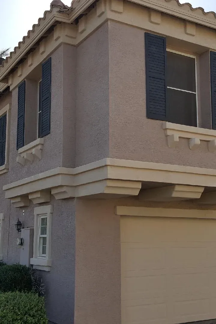 The same house repainted a soft mauve-grey with dark shutters