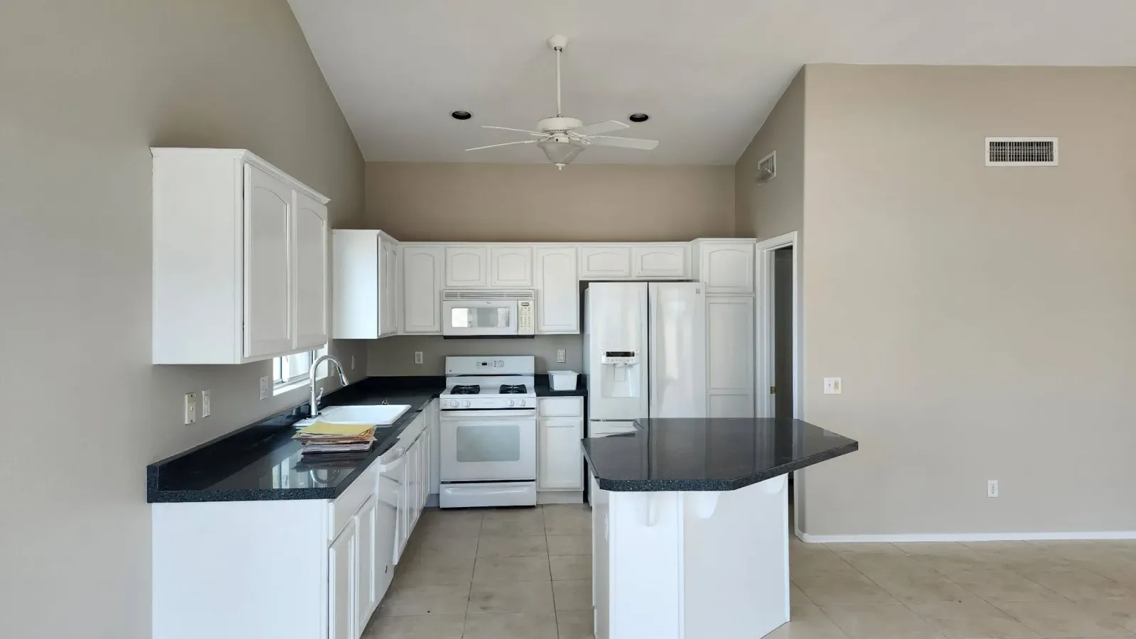 White painted kitchen cabinets with dark granite counters in an Arizona home