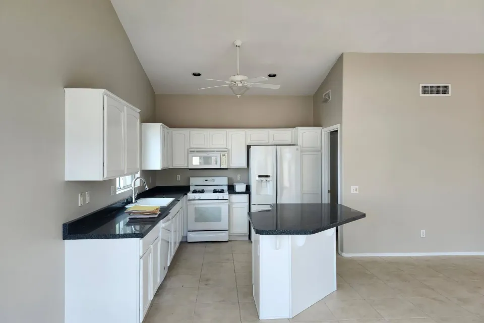 White painted kitchen cabinets with dark granite counters in an Arizona home
