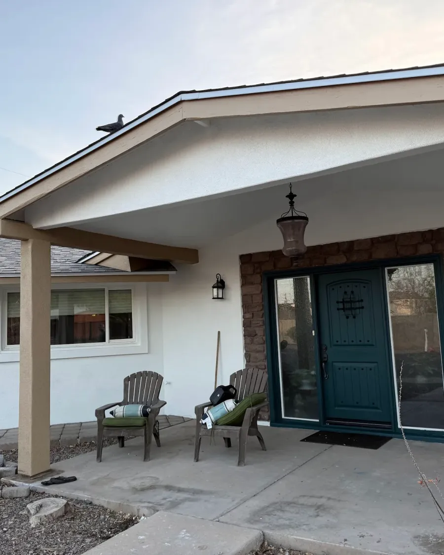 A white stucco ranch house with a covered front porch