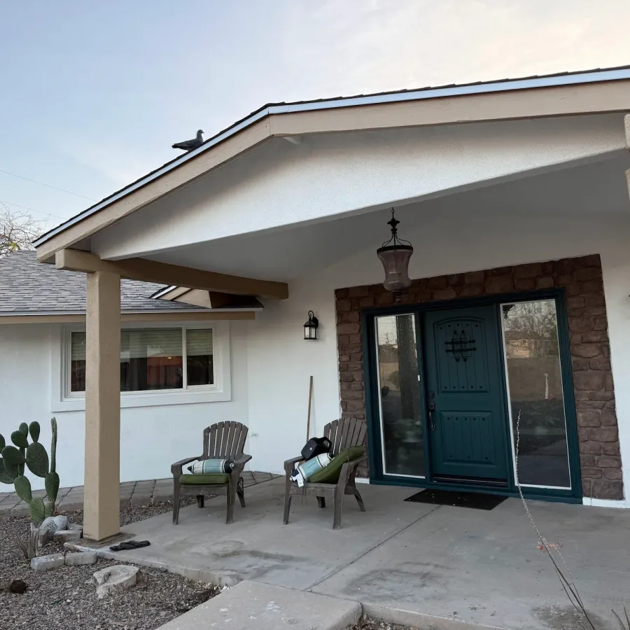 A white stucco ranch house with a covered front porch